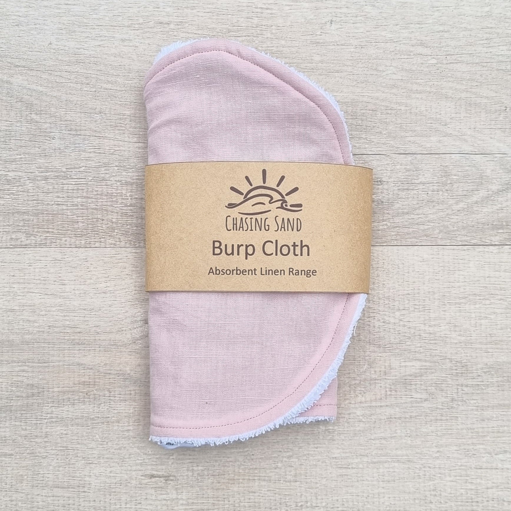 Burp Cloth - Pink Linen against wooden backdrop. Soft pastel pink colour.