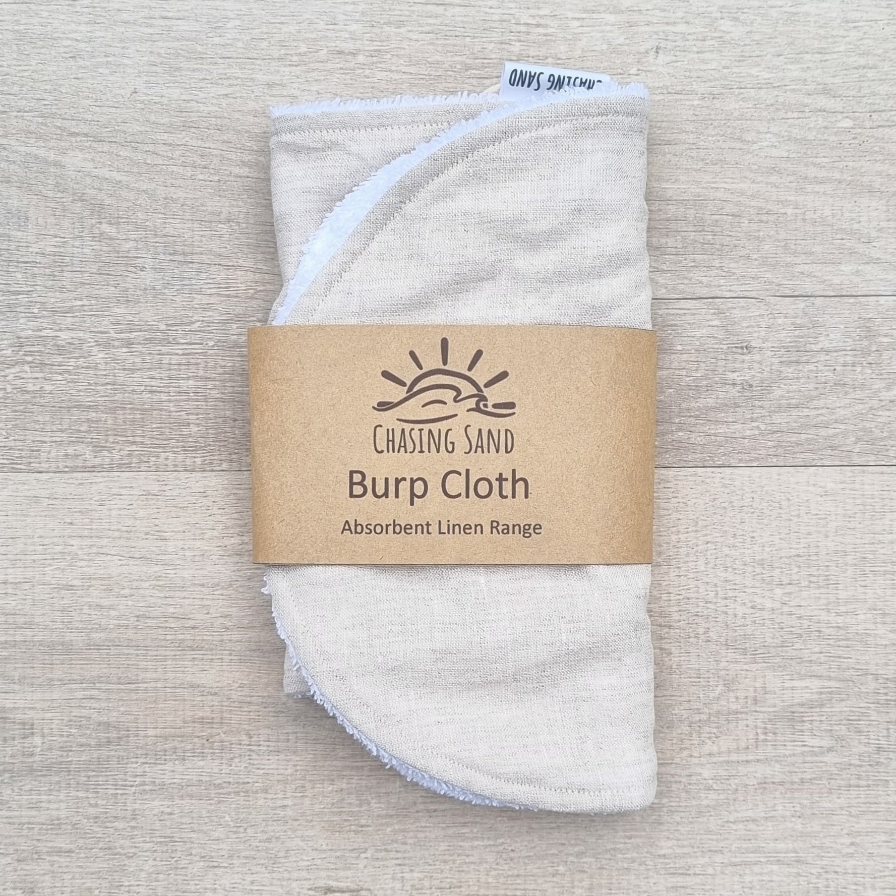 Burp Cloth - Oat Linen against wooden backdrop. Soft brown colour.