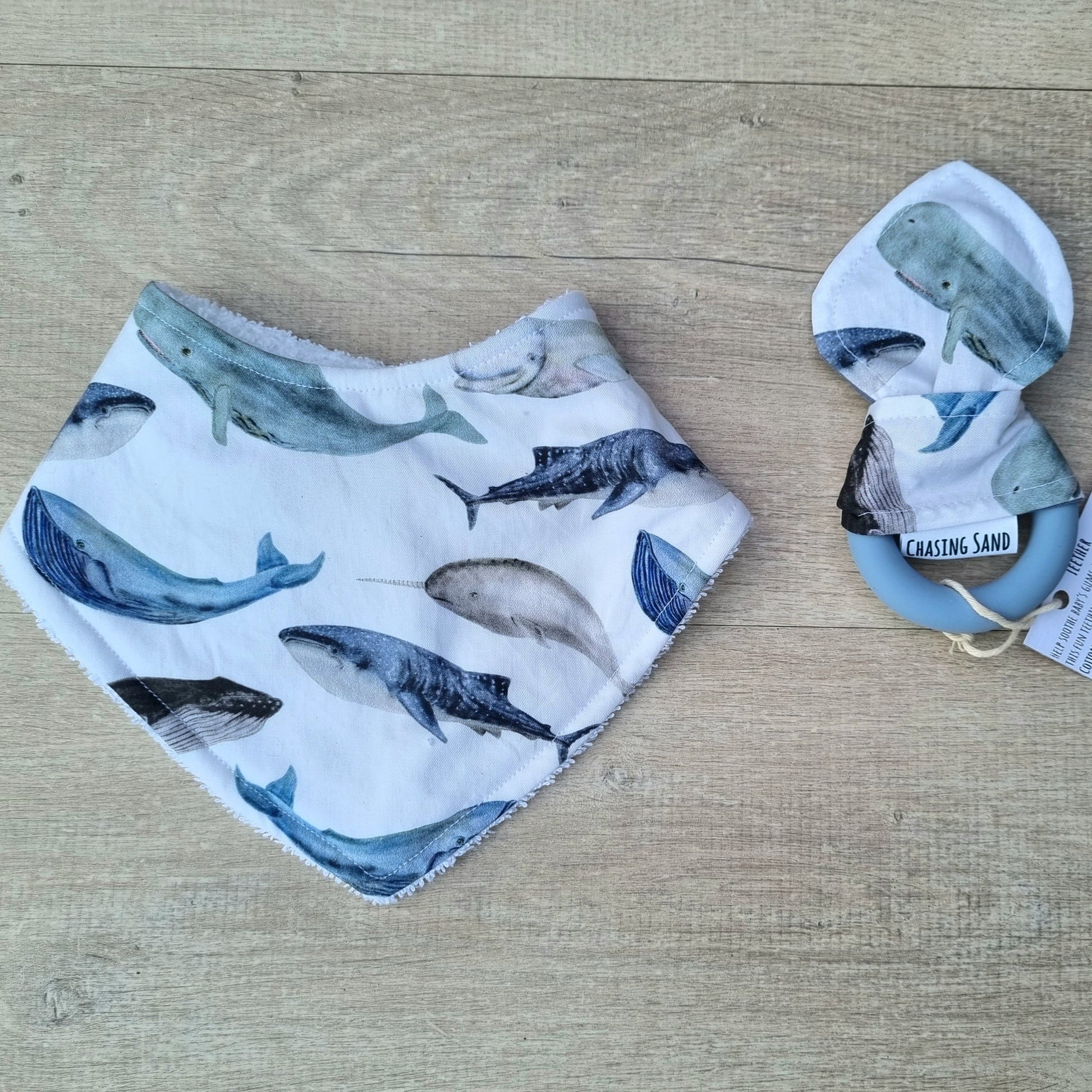 2 Piece Gift Set - Ocean against wooden backdrop. Whale illustrations on white background. Each set contains 1x Dribble Bib and 1x Teether.