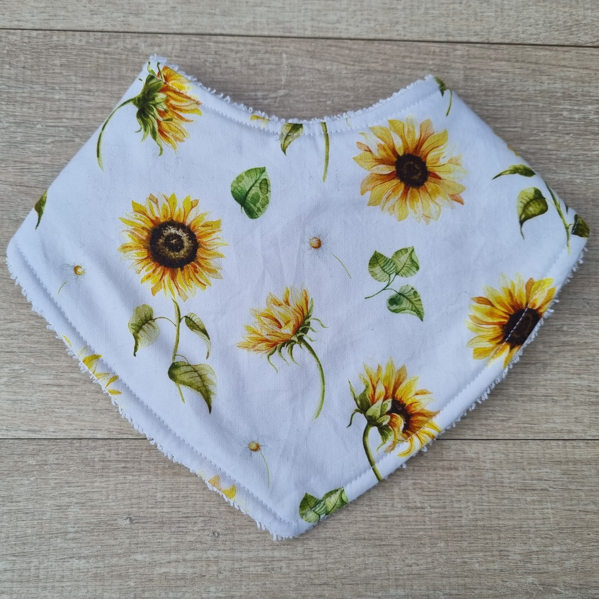 Dribble Bib - Sunflowers against wooden backdrop. Yellow sunflowers on white background.