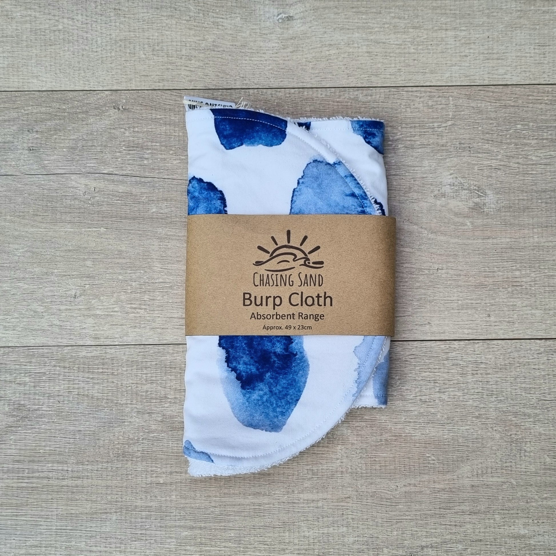 Burp Cloth - Watercolour against wooden backdrop. Blue watercolour patches on white background.