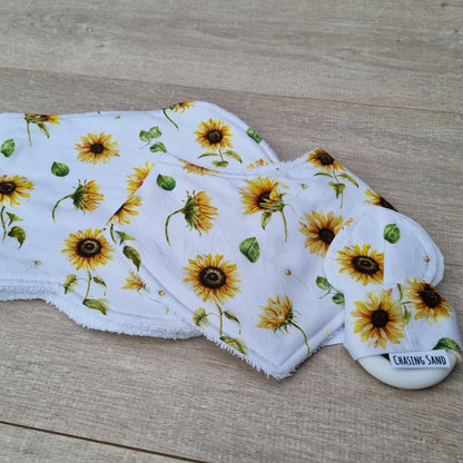 3 Piece Gift Set - Sunflowers against wooden backdrop. Yellow sunflowers on white background. Each set contains 1x Burp Cloth, 1x Dribble Bib and 1x Teether.