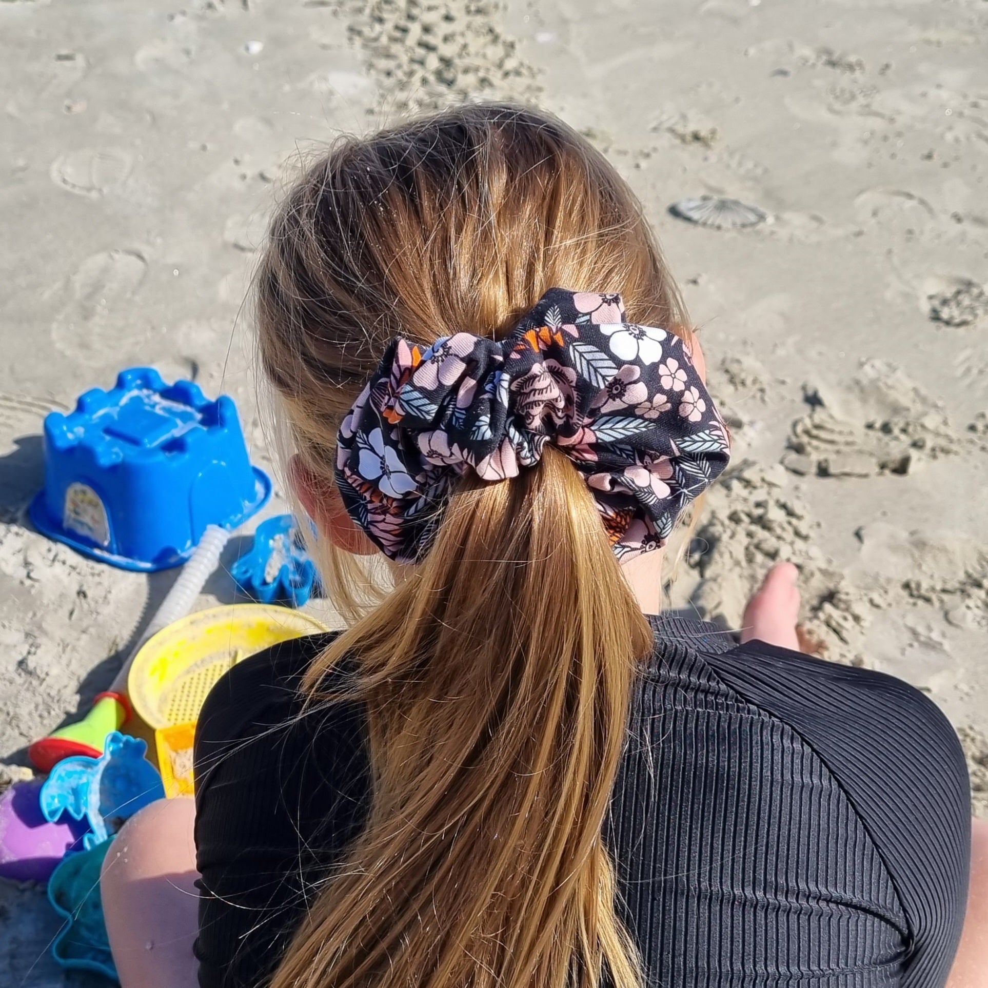 Scrunchie - Florence tied in girls hair at the beach. Orange and pink flowers with leaves on black background.
