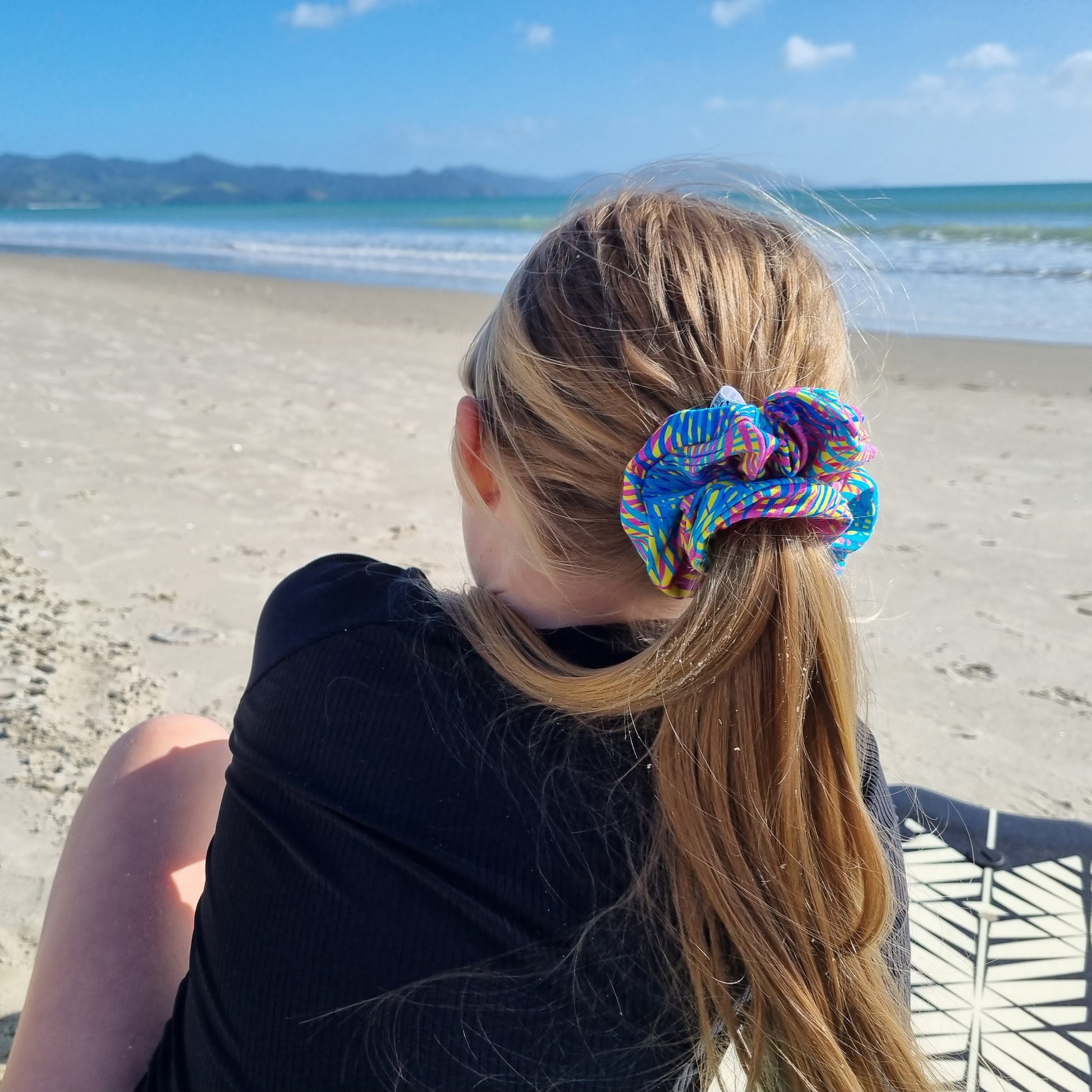 Scrunchie - Rainbow Stripes tied in girls hair at the beach. Blue, navy and hot pink stripes on yellow background.