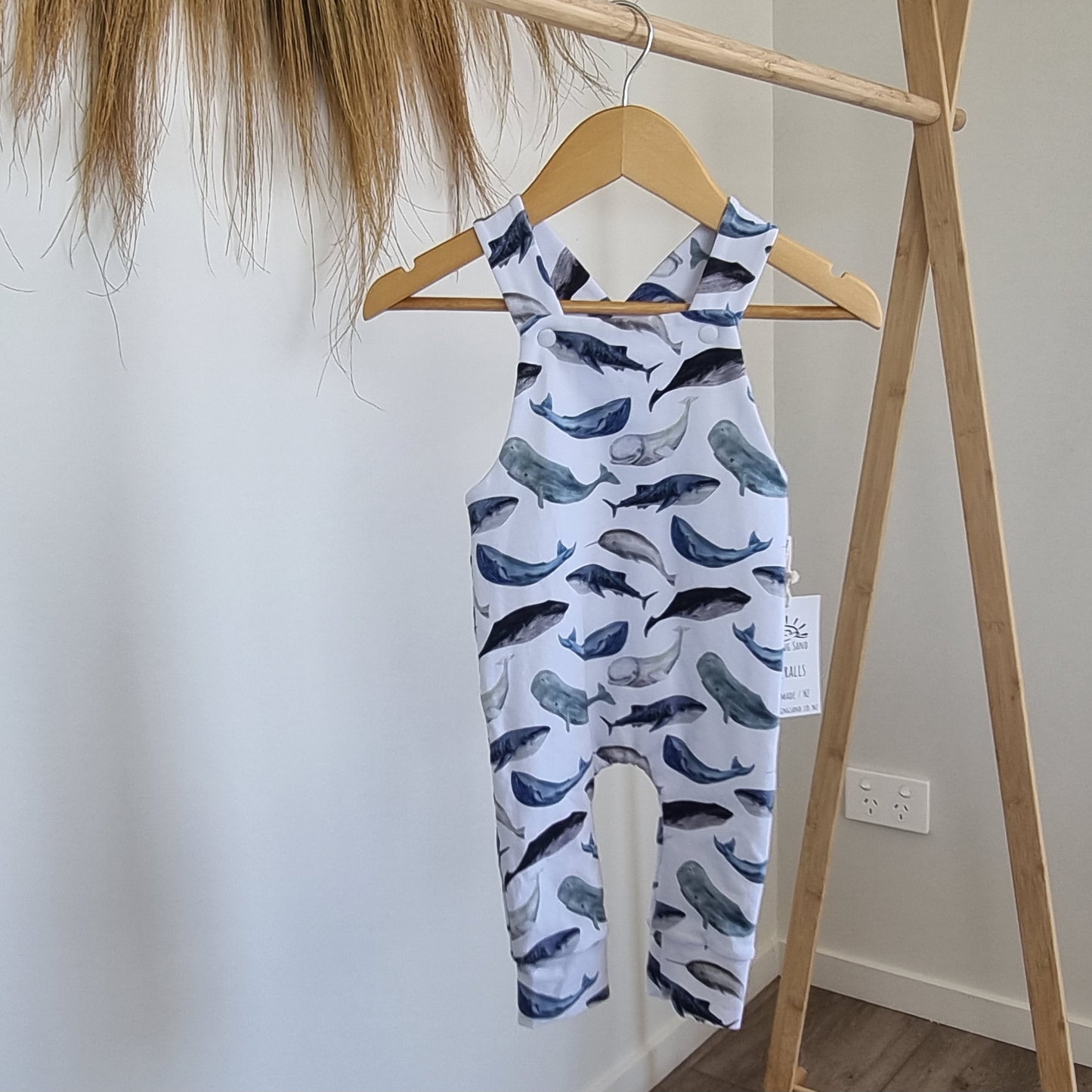 Long Overalls - Ocean hanging on wooden rack. Whale illustrations on white background. 