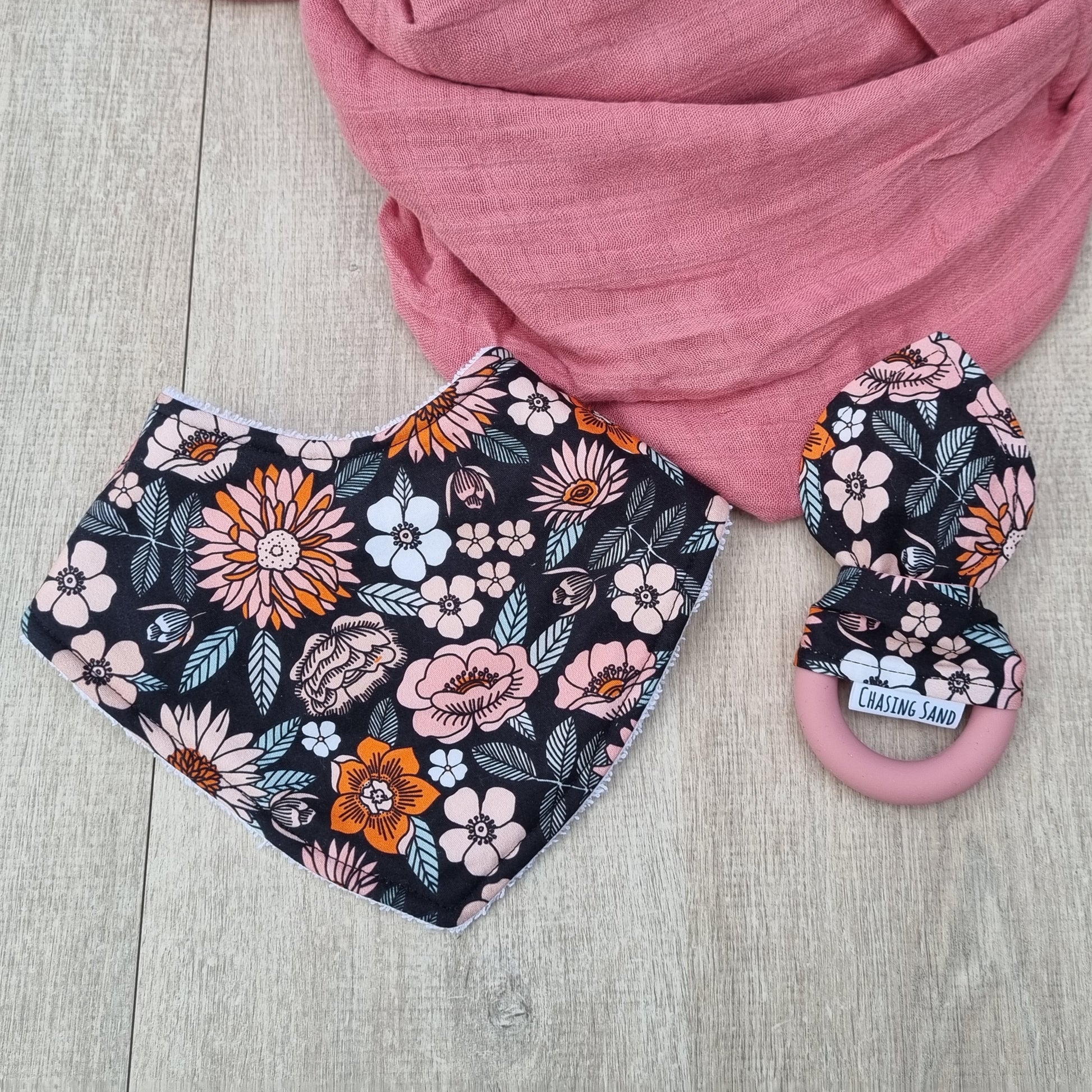 2 Piece Gift Set - Florence against wooden backdrop. Orange and pink flowers with leaves on black background. Each set contains 1x Dribble Bib and 1x Teether.