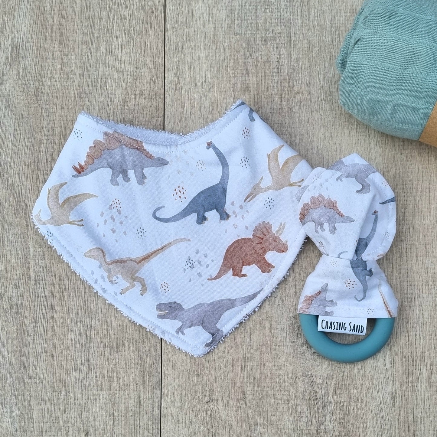 2 Piece Gift Set - Dino against wooden backdrop. Watercolour dinosaur illustrations white background. Each set contains 1x Dribble Bib and 1x Teether.