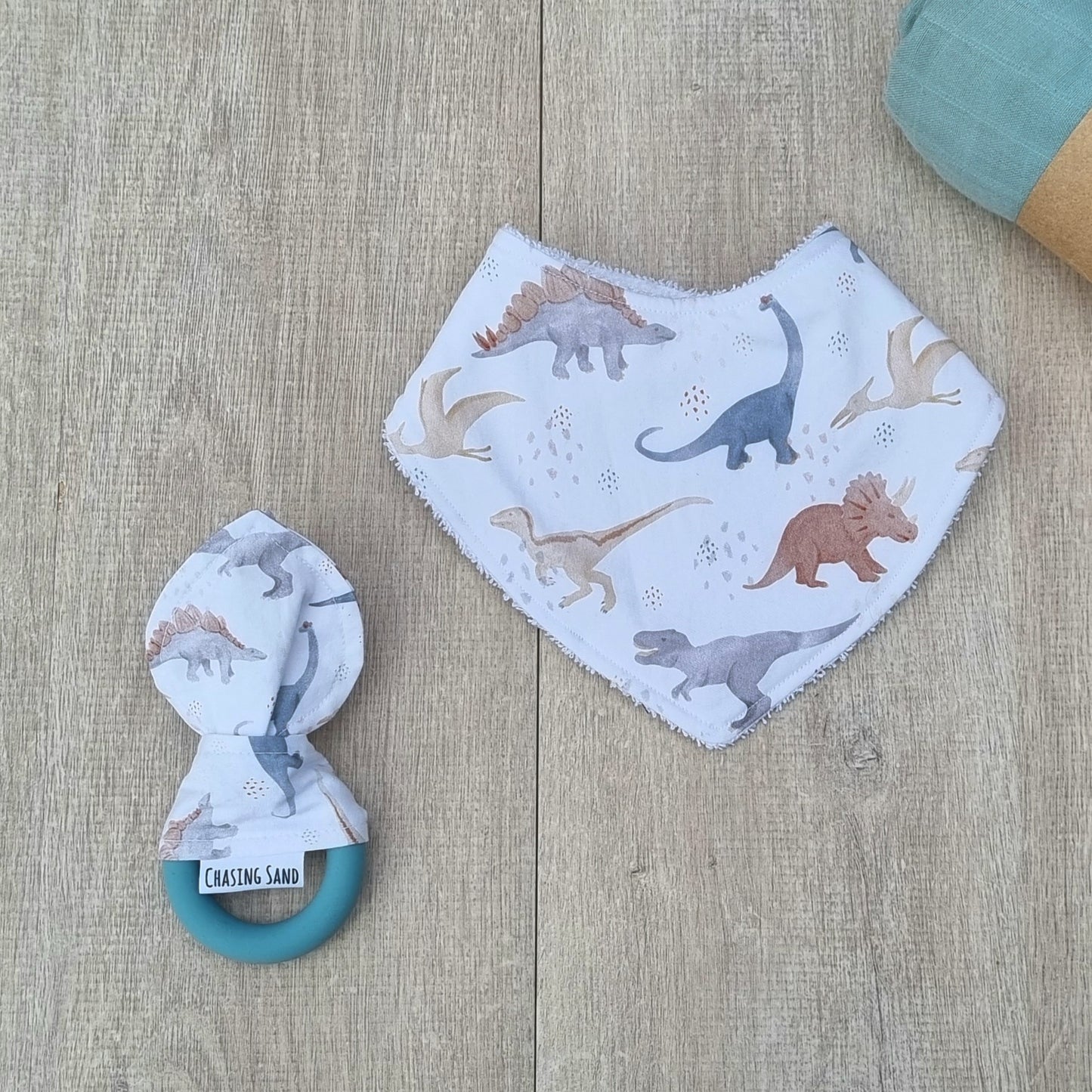 2 Piece Gift Set - Dino against wooden backdrop. Watercolour dinosaur illustrations white background. Each set contains 1x Dribble Bib and 1x Teether.