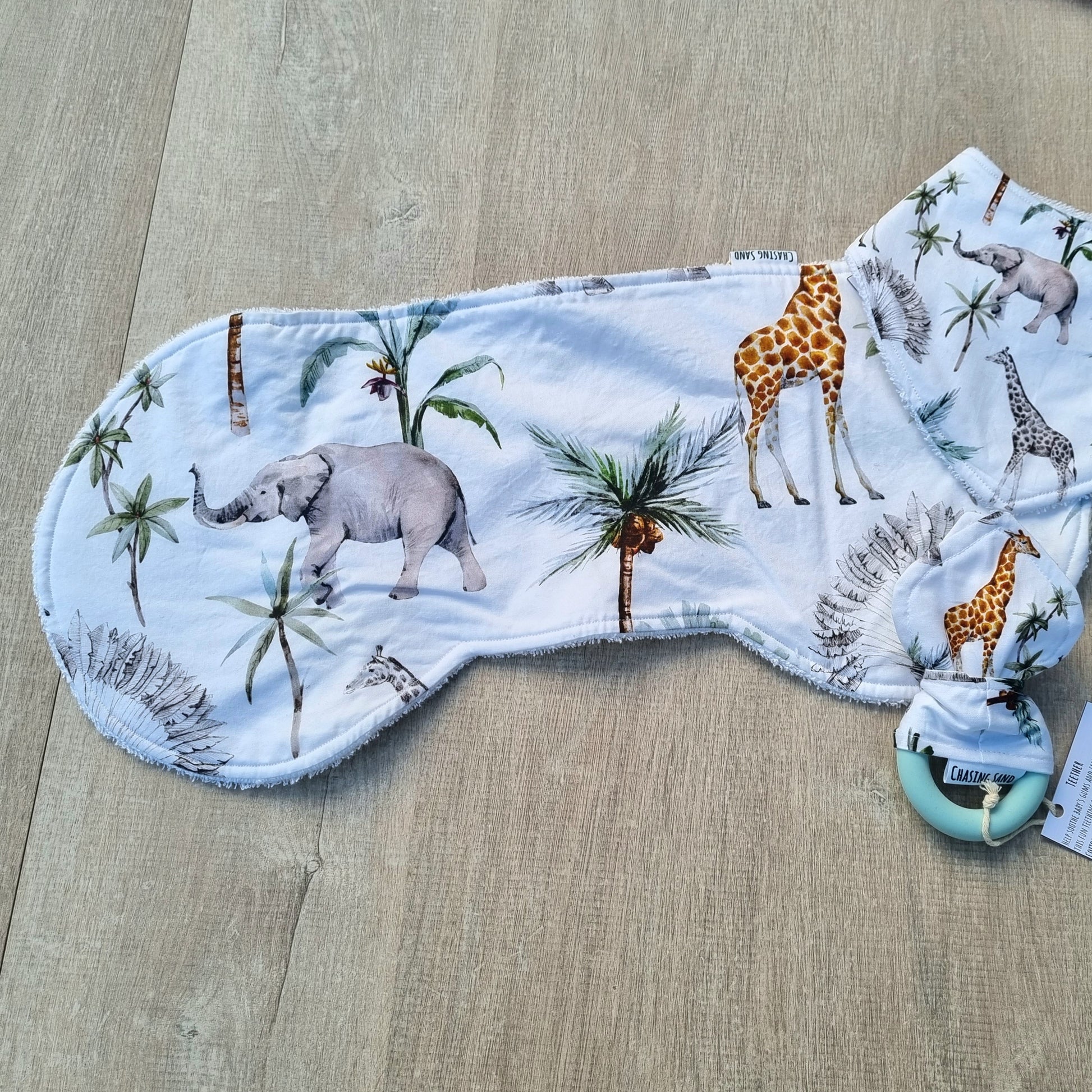 Burp Cloth - Safari against wooden backdrop. African animal and plant illustrations against white background.