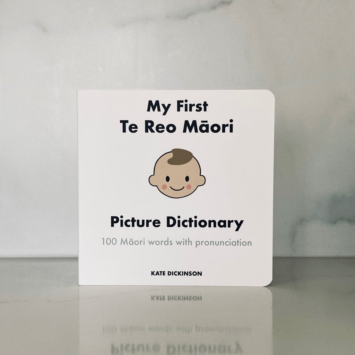 My First Te Reo Maori Picture Dictionary - Board Book. Cover: simple drawing of a baby smiling against a white background.