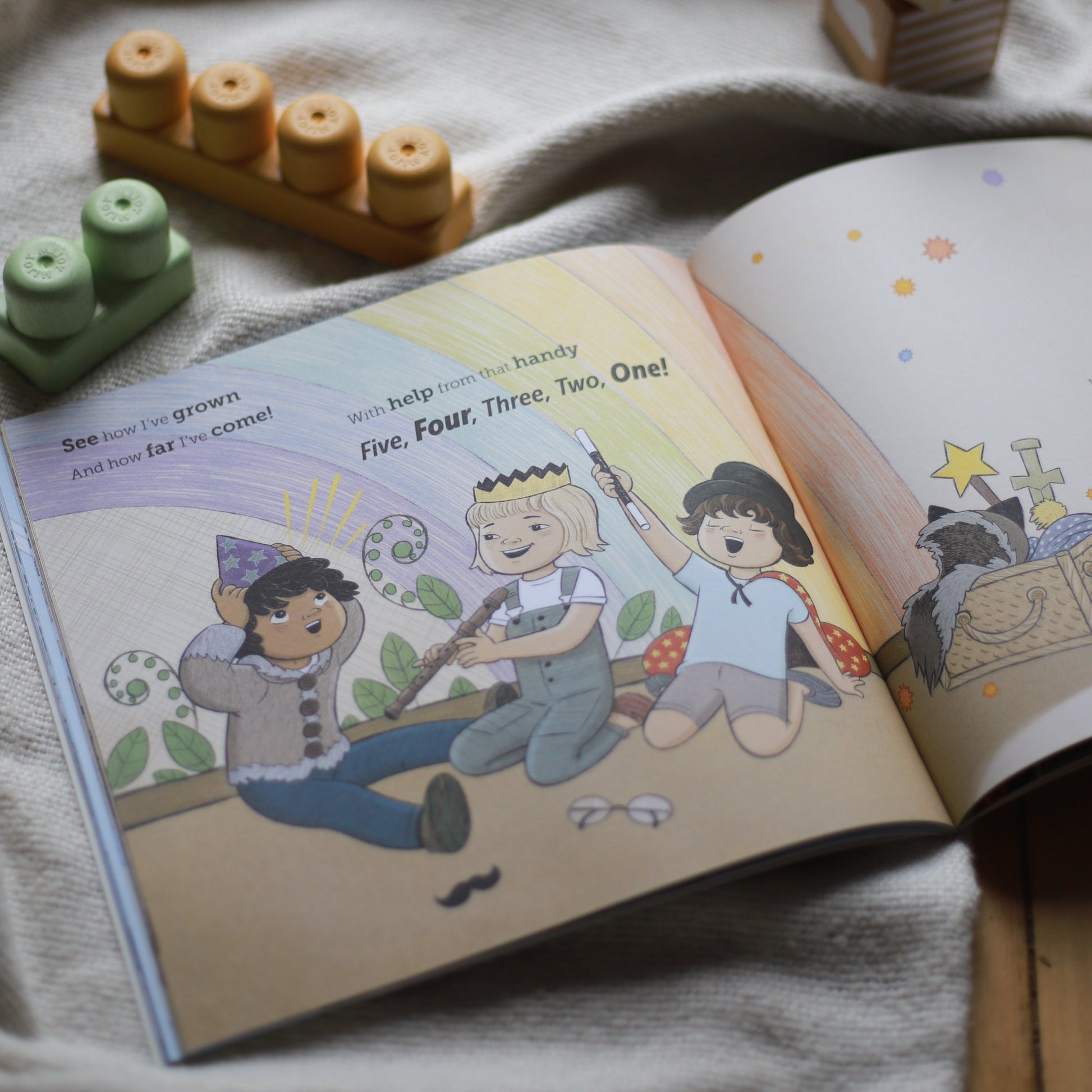 Page in the book showing three kids playing make-believe.