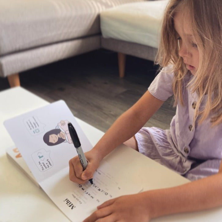 Girl writing her mihi (important details of her life) in Te Reo Māori for Preschoolers - Board Book.