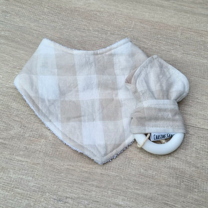 2 Piece Gift Set - Oat Gingham Linen against wooden backdrop. Soft brown checkered pattern on white. Each set contains 1x Dribble Bib and 1x Teether.