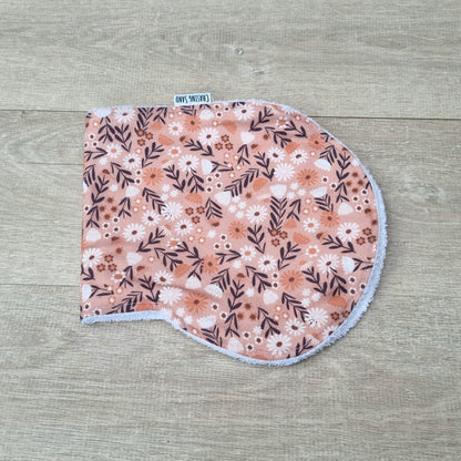 Burp Cloth - Spring Flowers against wooden backdrop. Small leaves and white daisies against pink background.